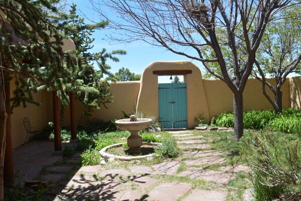 View from front door out to enclosed French door adobe privacy wall patio.