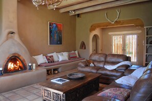 Living room  and view to glass French door entry. Please note the Fireplace has been switched to CANDLES ONLY as there has been trouble with smoke ruining the plaster walls.