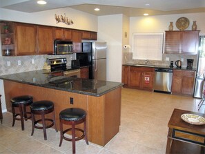Kitchen with Barstools and Stainless Steel Appliances