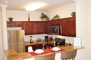 Kitchen with full size refrigerator, stainless appliances and cooking amenities