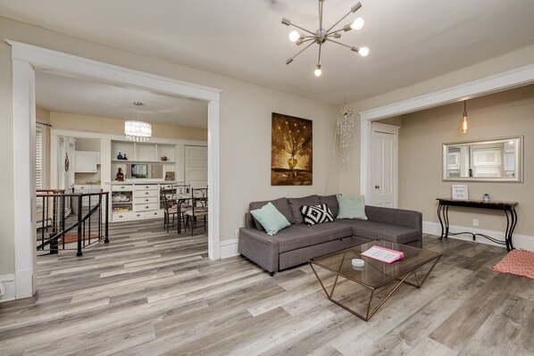 Living room with queen pull out couch, roku TV, adjacent to large dining room
