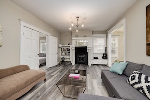 Living room with queen pull out couch, roku TV, adjacent to large dining room