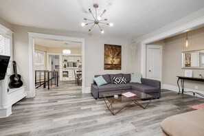 Living room with queen pull out couch, roku TV, adjacent to large dining room