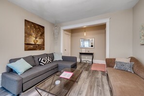 Living room with queen pull out couch, roku TV, adjacent to large dining room