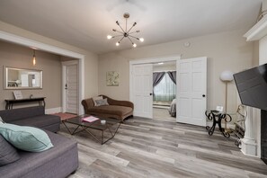 Living room with queen pull out couch, roku TV, adjacent to large dining room