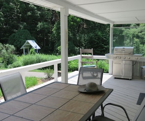 On the back porch with grill and seating for 9. Entry access into the cottage.