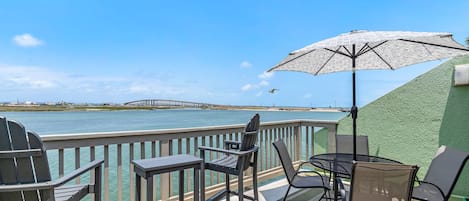 Beautiful views of the water off the living room balcony with new furniture and shaded umbrella