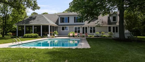 Back of the house with pool, large lawn area, hot tub, screened porch and deck