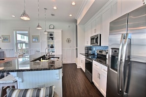 Kitchen with stainless steel appliances, granite counters and tile backsplash