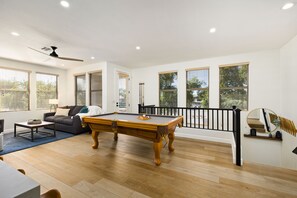 Pool table, living space, balcony access, and stairs from entry