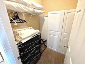 2 twin size cots are stored in the walk in closet of the master bedroom