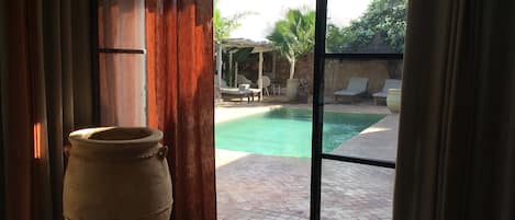 Vue féerique sur le jardin et la piscine à débordement