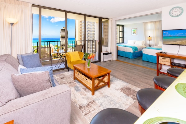 Stunning ocean view from the comfort of your own balcony and living room with a comfortable sofa bed, and coffee table.