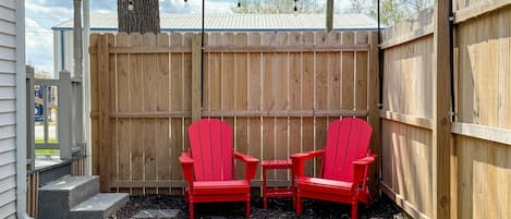 Fenced side yard with seating and twinkle lights