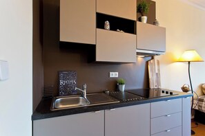 The kitchenette is equipped with ceramic hob and fume cupboard. 