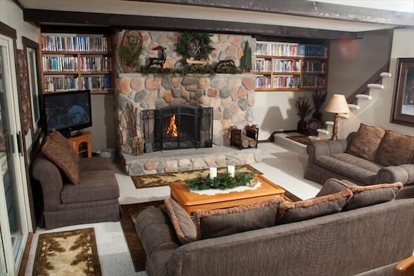Main floor living room area with gas fireplace, library, Directv, DVD & WiFi. 