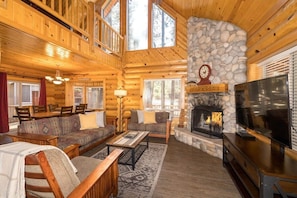 Living area with river rock fireplace. LCD TV. High Vaulted Ceilings