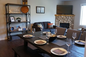 View from the dining area onto the living area with corner stone gas fireplace 