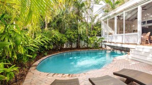 The pool is surrounded by chaise lounges...