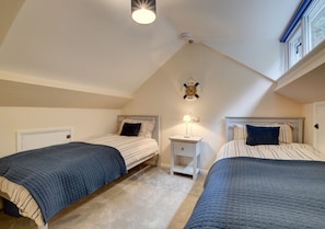Further steep stairs to the second floor opens out into a second attractive bedroom with sloping ceiling and twin beds