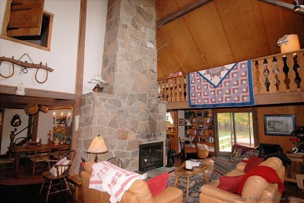 Interior sitting room with large stone fireplace and loft.