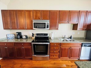 Fully Equipped Kitchen
Cook with ease in this spacious kitchen featuring rich wood cabinetry, stainless steel appliances, and granite countertops. Perfect for preparing home-cooked meals or quick snacks!