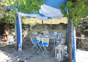 Weinloggia mit Tisch und Stühlen am Rande des Schwimmbades