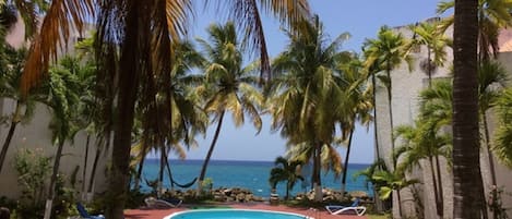 Paradise view of Chrissans Beach Resort - beachside, sunny pool and blue ocean