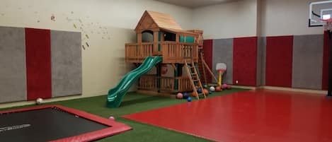 Playroom, with basketball, buried trampoline, putting green, and playhouse