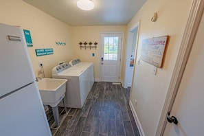 Laundry room with extra refrigerator.