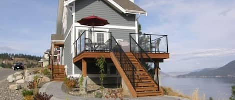 Cottage with deck and walkway overlooking Lake Okanagan. Fully landscaped.