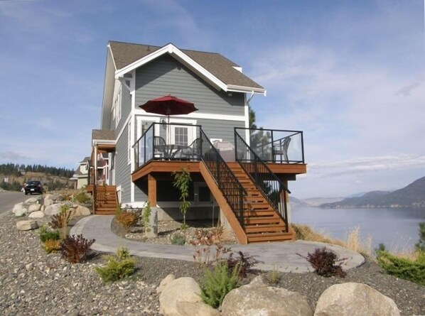 Cottage with deck and walkway overlooking Lake Okanagan. Fully landscaped.