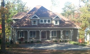 Street side view of home with lake in the back ground.