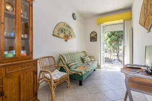 Living room with sleeping sofa for 2 and entrance to the balcony