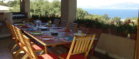 La grande terrasse couverte permet de manger face à la mer, la plancha