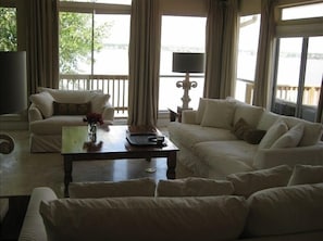 Living Area with woodburning fireplace & 3 walls of windows overlooking the lake