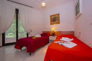 Chambre à deux lits avec vue sur le jardin et accès à la terrasse
