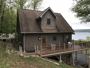 Corner view showing the wrap around balcony and the upper patio and fire pit.