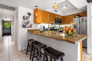 Kitchen with island and refrigerator.