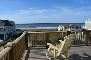 View off the front deck. The beach access is to the right of the yellow house.