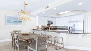 Modern kitchen with granite, acrylic barstools & dining table—seats 10 total