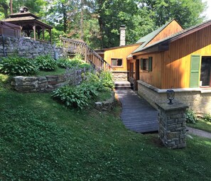 parking side gazebo and steps down to cottage. flower beds all around!