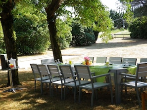 Grande table pour le repas du soir,  près du BBQ, du boulodrome et du portique 