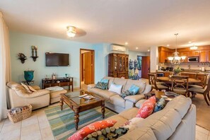 The living room has two comfortable couches and a 55 inch flat screen TV with lots of English channels