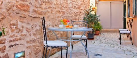 Zona de desayuno en el patio con mesa, sillas y hamacas