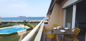 Terrace with  table and chairs overlooking the sea and the pool