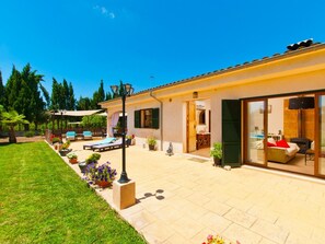 Luminous facade of the villa and garden facing the pool