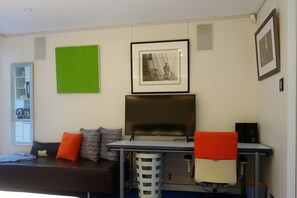 Smart TV in large bedroom with  Vitra chair for added luxury and comfort. 