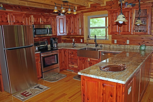 Custom kitchen with stainless appliances, copper sink and granite countertops.