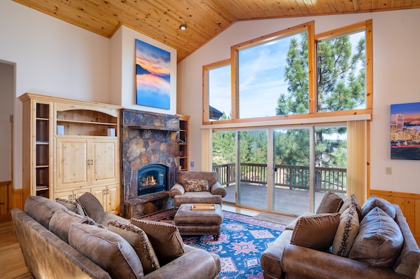 Pinnacle Loop Mountain Retreat - a SkyRun North Tahoe Property - Living Room/Grand Open Floor Plan (Upper Level) - Enjoy the warmth and depth of this grand room and its open floor plan. The cathedral ceiling, wall of windows and large rock mantel gas fireplace offers breathtaking views from just about any spot in the room!